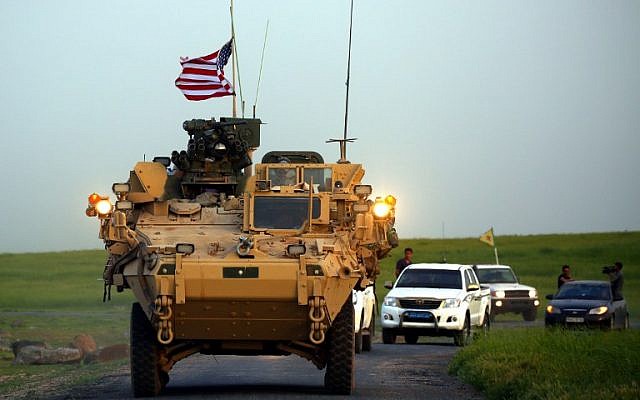 Las fuerzas estadounidenses, acompañadas por combatientes de las Unidades de Protección de los Pueblos Kurdos (YPG), conducen sus vehículos blindados cerca del pueblo sirio de Darbasiyah, en la frontera con Turquía, el 28 de abril de 2017. (Delil Souleiman / AFP)