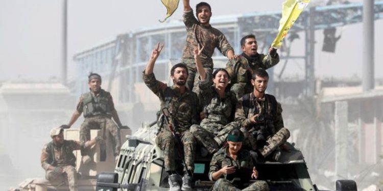 Milicianos liderados por kurdos viajan sobre vehículos militares mientras celebran la victoria sobre el Estado Islámico en Raqqa, Siria, 17 de octubre de 2017. (Crédito de la foto: REUTERS / ERIK DE CASTRO)