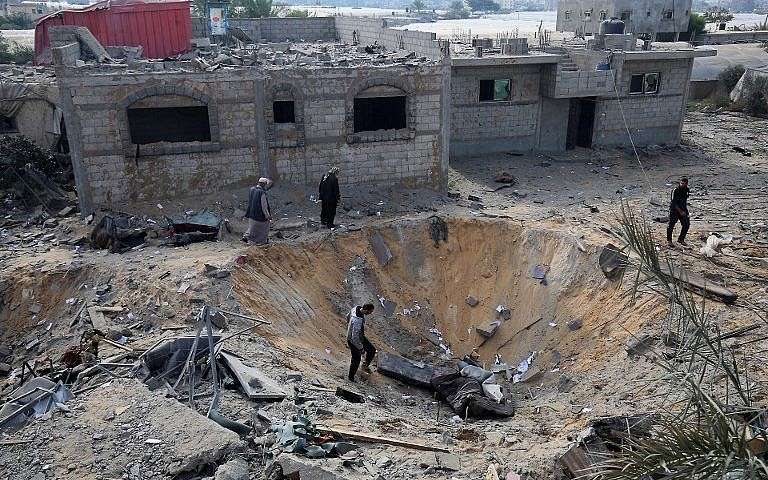 Árabes inspeccionan un cráter causado por un ataque aéreo israelí a principios de esta semana durante los combates con grupos terroristas palestinos, en Rafah, en el sur de la Franja de Gaza, el 14 de noviembre de 2018. (Said Khatib / AFP)