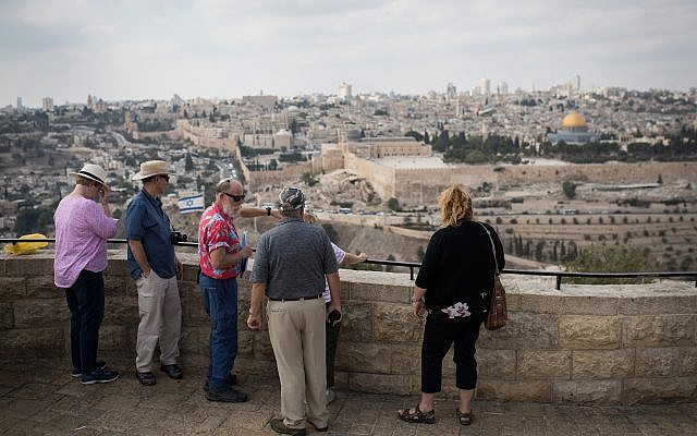 Los turistas escuchan a un guía turístico en el mirador del Monte de los Olivos con vista a la ciudad vieja de Jerusalén, el 11 de octubre de 2018. (Hadas Parush / Flash90)