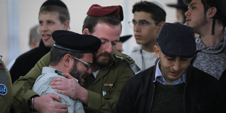 Amigos y familiares lloran durante el funeral del soldado de las FDI Yosef Cohen, asesinado en un ataque terrorista en Cisjordania, en la funeraria Shamgar en Jerusalén el 14 de diciembre de 2018. (Yonatan Sindel / Flash90)