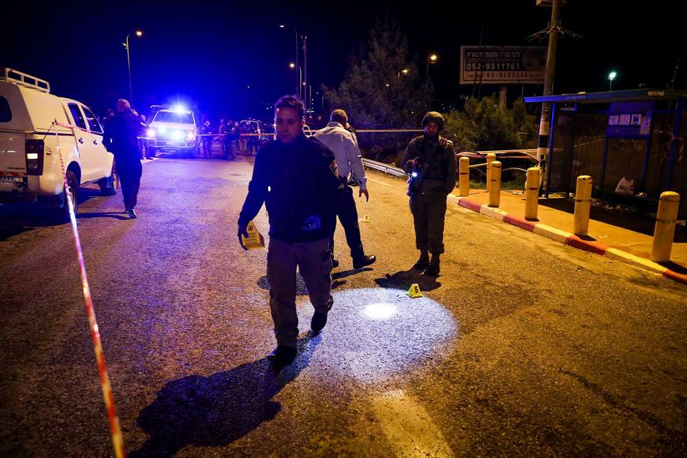 Los soldados y la policía israelíes inspeccionan la escena de un ataque terrorista en la entrada del poblado israelí de Ofra en Cisjordania, el 9 de diciembre de 2018. (Ofer Meir / Flash 90)