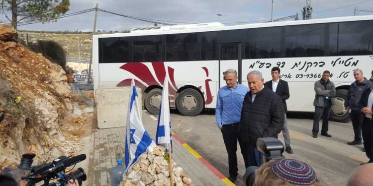 El primer ministro Benjamin Netanyahu (R) visita Givat Assaf Junction con el presidente del Consejo Local de Beit El, Shai Alon, donde dos soldados de las FDI murieron en un ataque terrorista, el 18 de diciembre de 2018. (Consejo Local de Beit El)