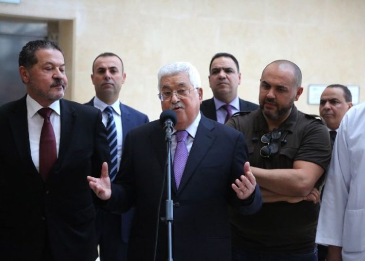 El presidente de la Autoridad Palestina, Mahmoud Abbas, flanqueado por sus dos hijos, Yasser, a la izquierda, y Tarek, a la derecha, hace una breve declaración antes de abandonar el hospital de Ramallah el 28 de mayo de 2018. (AFP Photo / Abbas Momani)