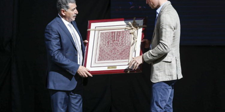 El príncipe Guillermo de Gran Bretaña recibió un regalo de Musa Hadid, el alcalde de Ramallah, en una recepción durante su visita al municipio de la ciudad de Cisjordania el 27 de junio de 2018. (AFP PHOTO / POOL / ABBAS MOMANI)