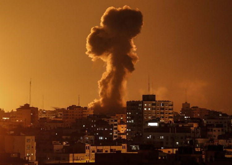Una fotografía tomada el 12 de noviembre de 2018, muestra un humo que se eleva sobre el edificio donde se encuentra la estación de televisión al-Aqsa de Hamas en la Franja de Gaza durante un ataque aéreo israelí. (Mahmud Hams / AFP)