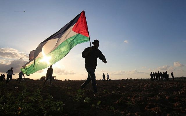 Un manifestante palestino porta una bandera nacional durante una manifestación cerca de la frontera entre Israel y Khan Yunis en el sur de la Franja de Gaza, el 21 de diciembre de 2018. (Foto de SAID KHATIB / AFP)