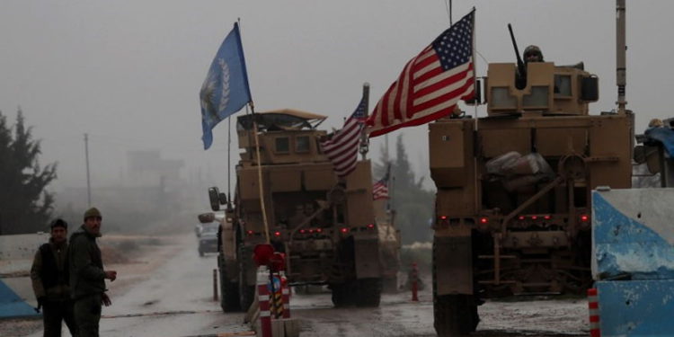 Una línea de vehículos militares de Estados Unidos atraviesa un puesto de control de las Fuerzas de Seguridad Internas en Manbij cuando se dirigen a su base en las afueras de la ciudad del norte de Siria el 30 de diciembre de 2018. (Delil SOULEIMAN / AFP)