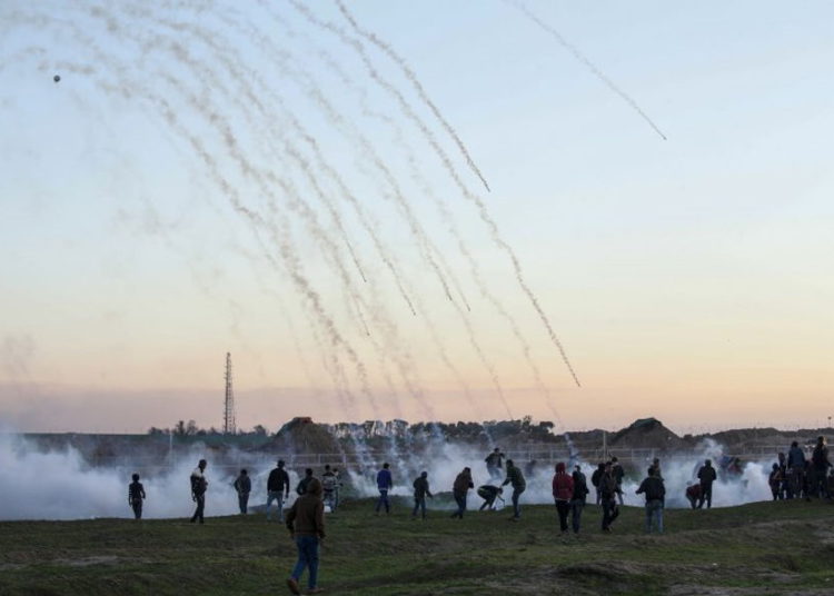 Recipientes de gas lacrimógeno cayendo en medio de manifestantes palestinos durante enfrentamientos con fuerzas israelíes al otro lado de la frontera, al este de la ciudad de Gaza, 18 de enero de 2019. (Dijo KHATIB / AFP)