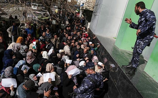 Las fuerzas de seguridad leales a Hamás organizan una línea fuera de la oficina central de correos en la ciudad de Gaza el 26 de enero de 2019, mientras los palestinos se reúnen para recibir ayuda financiera del gobierno de Qatar, que se otorga a familias empobrecidas. (Mahmud Hams / AFP)