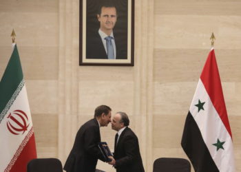 El primer ministro sirio, Imad Khamis, a la derecha, y el vicepresidente iraní, Eshaq Jahangiri, se dan la mano tras la firma de un acuerdo en la capital, Damasco, el 28 de enero de 2019. (LOUAI BESHARA / AFP)
