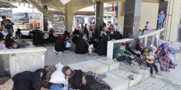 Los sirios desplazados que huyeron con sus familias en las áreas controladas por el Estado Islámico en Raqqa, Deir Ezzor y Mayadeen se reúnen en la estación de autobuses de Ramussa en Aleppo el 4 de julio de 2017. (AFP PHOTO / JOSEPH EID)