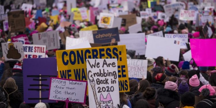 Los manifestantes sostienen carteles durante la Marcha de Mujeres el 19 de enero de 2019 en Washington, DC. Se están realizando demostraciones en ciudades de los EE. UU. En el tercer evento anual destinado a destacar el cambio social y celebrar los derechos de las mujeres en todo el mundo. (Zach Gibson / Getty Images / AFP)
