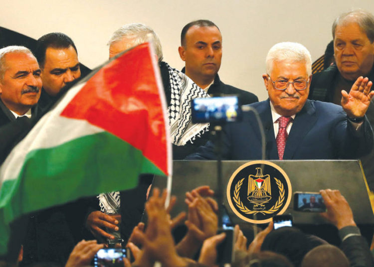 El PRESIDENTE DE LA AUTORIDAD PALESTINA Mahmoud Abbas saluda a la audiencia durante una ceremonia en Ramallah el 31 de diciembre, que marca el 54 aniversario de la fundación de Fatah. (Crédito de la foto: MOHAMAD TOROKMAN / REUTERS)