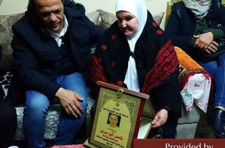 En la foto, la madre de Nasser y Mahmoud Abu Srur aceptan certificados de honor. (Fuente: Facebook.com.iqlimfateh, 5 de enero de 2019.) (MEMRI)