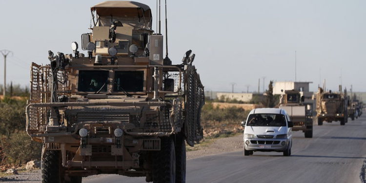 Un convoy de tropas de EE. UU. Conduce por una carretera que conduce a la línea del frente con combatientes respaldados por Turquía en el norte de Siria, 31 de marzo de 2018. (Foto de AP / Hussein Malla, archivo)