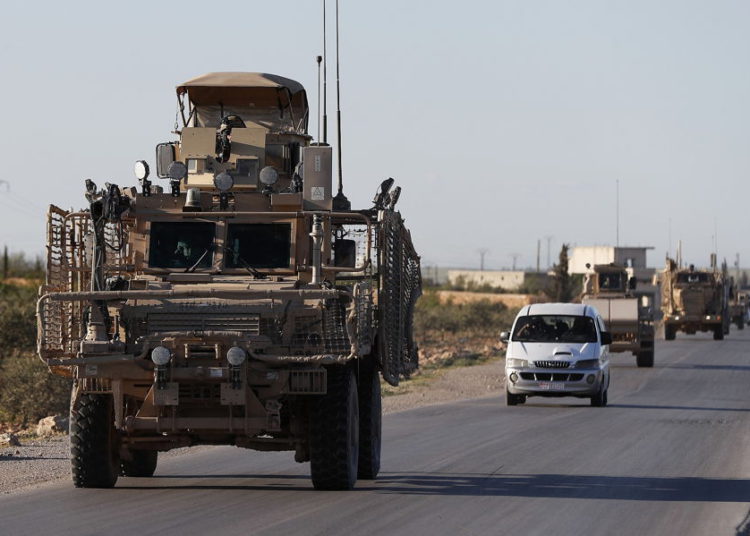 Un convoy de tropas de EE. UU. Conduce por una carretera que conduce a la línea del frente con combatientes respaldados por Turquía en el norte de Siria, 31 de marzo de 2018. (Foto de AP / Hussein Malla, archivo)