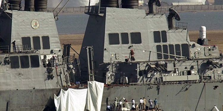 Los expertos examinan el hoyo en el costado del USS Cole en Adén el viernes 13 de octubre de 2000. Una poderosa explosión el jueves abrió un agujero en un destructor de la Marina de los EE. UU. En el puerto yemení de Adén, matando a 17 marineros e hiriendo a otros 30. Foto / Dimitri Messinis)