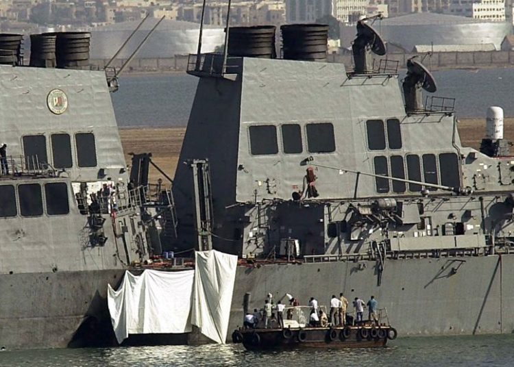 Los expertos examinan el hoyo en el costado del USS Cole en Adén el viernes 13 de octubre de 2000. Una poderosa explosión el jueves abrió un agujero en un destructor de la Marina de los EE. UU. En el puerto yemení de Adén, matando a 17 marineros e hiriendo a otros 30. Foto / Dimitri Messinis)