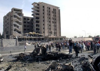 Foto ilustrativa de sirios reunidos frente a un edificio de inteligencia militar dañado donde explotaron dos bombas, en el barrio de Qazaz en Damasco, Siria, 10 de mayo de 2012. (Bassem Tellawi / AP)