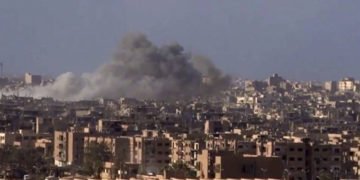 Archivo: Humo y escombros en aumento después del bombardeo del gobierno sirio de la ciudad de Deir el-Zour durante una batalla contra el Estado Islámico en 2017 (SANA a través de AP)