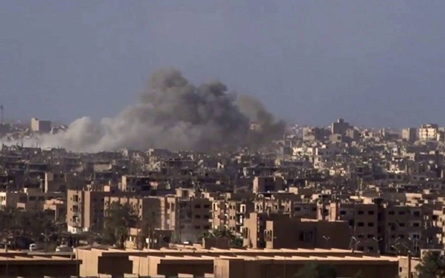 Archivo: Humo y escombros en aumento después del bombardeo del gobierno sirio de la ciudad de Deir el-Zour durante una batalla contra el Estado Islámico en 2017 (SANA a través de AP)