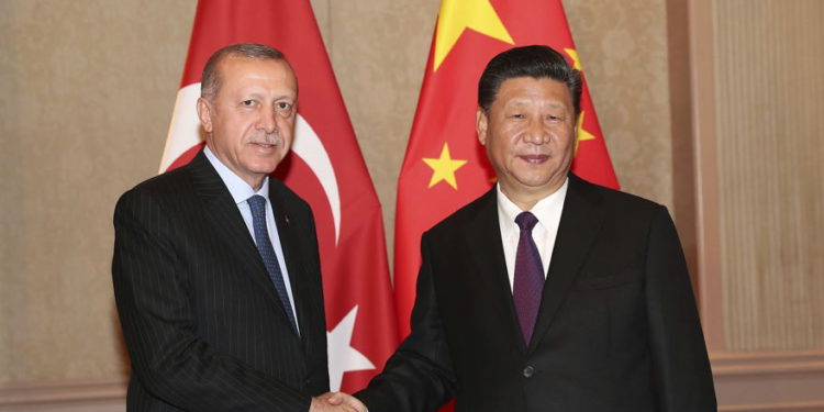 El presidente de Turquía, Recep Tayyip Erdogan, a la izquierda, y el presidente de China, Xi Jinping, se dan la mano antes de su reunión en Johannesburgo, Sudáfrica, el 26 de julio de 2018 (Servicio de Prensa Presidencial a través de AP, Pool)