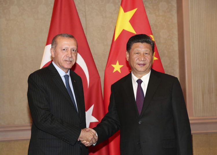 El presidente de Turquía, Recep Tayyip Erdogan, a la izquierda, y el presidente de China, Xi Jinping, se dan la mano antes de su reunión en Johannesburgo, Sudáfrica, el 26 de julio de 2018 (Servicio de Prensa Presidencial a través de AP, Pool)