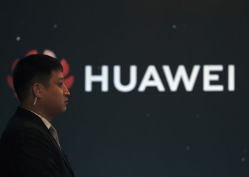 En esta foto del 9 de enero de 2019, un guardia de seguridad se encuentra cerca del logotipo de la compañía Huawei durante un evento de lanzamiento de un nuevo producto en Beijing (AP Photo / Andy Wong)