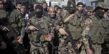 Hombres armados enmascarados participan en el funeral de Mahmoud al-Nabahin, miembro del grupo militar del grupo terrorista Hamas, en el campamento de refugiados de Buriej, en el centro de la Franja de Gaza, el 23 de enero de 2019. (Foto AP / Khalil Hamra)