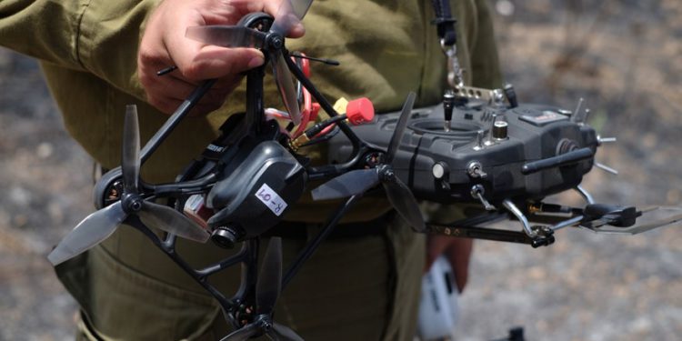Un operador de las FDI sostiene su avión no tripulado y control remoto el 7 de junio de 2018, en un campo quemado por "cometas de fuego" de la Franja de Gaza. (Judah Ari Gross / Tiempos de Israel)