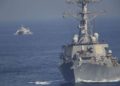 El USS Mitscher, parte de un grupo de ataque liderado por el portaaviones USS John C. Stennis, navega mientras un barco de la Guardia Revolucionaria Iraní lo oculta el 21 de diciembre de 2018. (AP Photo / Jon Gambrell)