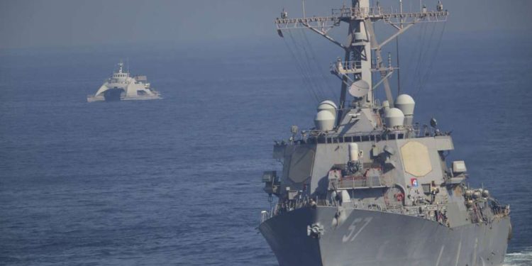 El USS Mitscher, parte de un grupo de ataque liderado por el portaaviones USS John C. Stennis, navega mientras un barco de la Guardia Revolucionaria Iraní lo oculta el 21 de diciembre de 2018. (AP Photo / Jon Gambrell)