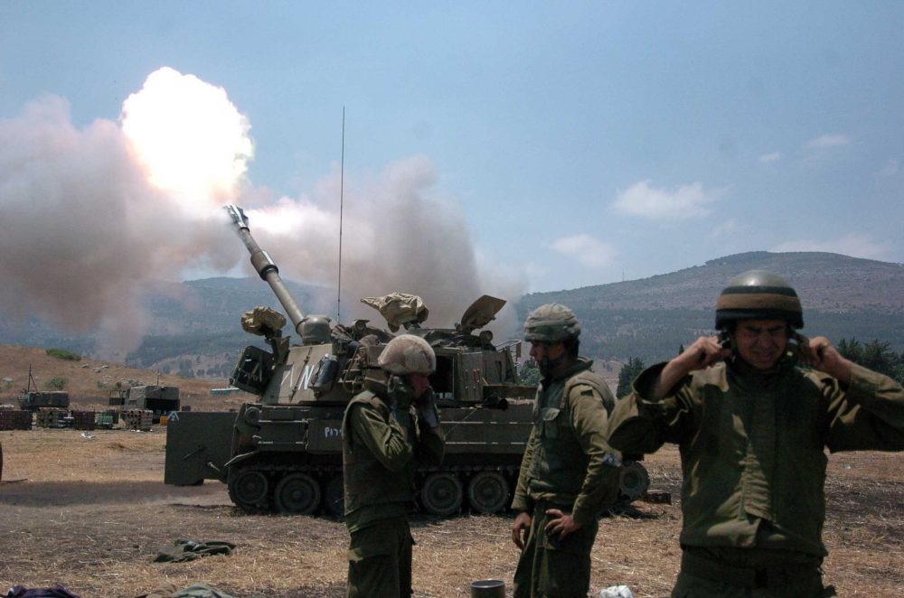 Los soldados israelíes se tapan los oídos mientras un obús dispara en el Líbano desde Kiryat Shemona el 20 de julio de 2006 durante la Segunda Guerra del Líbano. Crédito: Guy Assayag / Flash90.