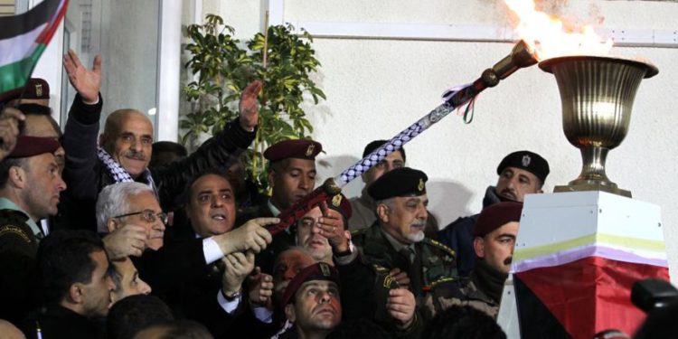 El presidente de la Autoridad Palestina, Mahmoud Abbas, enciende una antorcha conmemorativa en Ramallah el martes temprano. (Crédito de la foto: Hadas Parush / Flash90)
