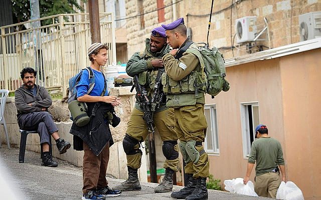 Soldados de las FDI hablan con un joven judío en la dividida ciudad de Hebrón, 6 de noviembre de 2015 (Mendy Hechtman / FLASH90)