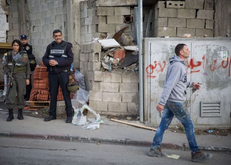 Ilustrativo: un hombre palestino pasa junto a los oficiales de la policía israelí en la entrada al campamento de refugiados de Shuafat en Jerusalén Este el 2 de diciembre de 2015. (Hadas Parush / Flash90)