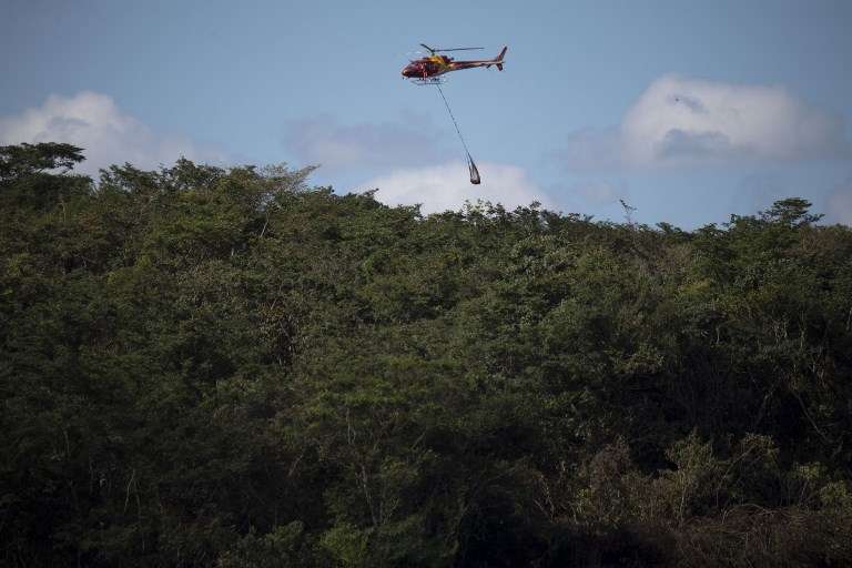 Un helicóptero de bomberos transporta el cuerpo de una víctima del colapso de la represa del viernes en una mina de mineral de hierro perteneciente a la gigante minera brasileña Vale, cerca de la ciudad de Brumadinho, Estado de Minas Gerais, sureste de Brasil, el 28 de enero de 2019. (Mauro PIMENTEL / AFP)