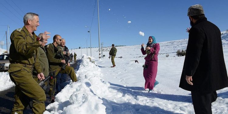El entonces jefe de personal de las FDI Benny Gantz tiene una pelea de bolas de nieve con una familia de palestinos a lo largo de la ruta 60 de la Ribera Occidental, el 15 de diciembre de 2013. (Judah Ari Gross / Fuerzas de Defensa de Israel)