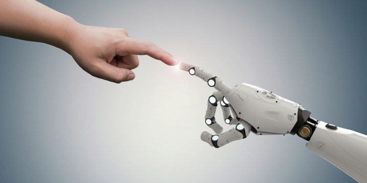 Una imagen ilustrativa de un robot y una mano humana (PhonlamaiPhoto; iStock by Getty Images)