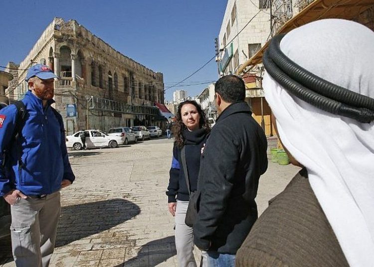 Los miembros de la Presencia Internacional Temporal en Hebrón (TIPH) hablan con los palestinos locales mientras caminan en la ciudad de Cisjordania el 29 de enero de 2019. (Hazem Bader / AFP)
