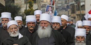 Los residentes drusos de los Altos del Golán llevan un retrato del presidente sirio Bashar al-Assad durante un mitin en la aldea de Majdal Shams el 14 de febrero de 2019 (JALAA MAREY / AFP)