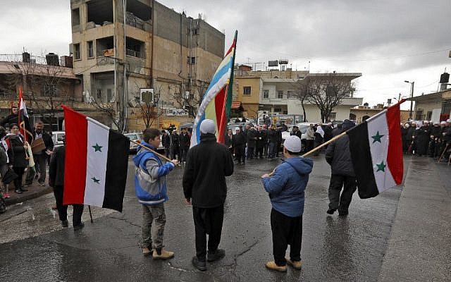 Los jóvenes drusos de los Altos del Golán sostienen las banderas sirias y drusas durante un mitin en la aldea de Majdal Shams en los Altos del Golán el 14 de febrero de 2019 (JALAA MAREY / AFP)