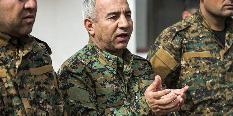 El comandante de las Fuerzas Democráticas Sirias respaldado por Estados Unidos, Jia Furat (C), responde las preguntas de los reporteros cerca del campo petrolífero de Omar en la provincia oriental de Deir Ezzor en Siria el 16 de febrero de 2019. (Fadel Senna / AFP)