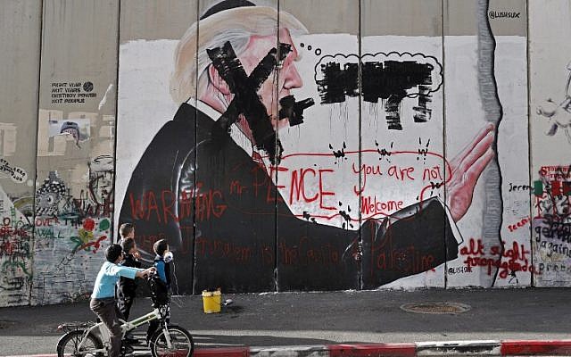 Los niños palestinos miran graffiti que representan al presidente de los EE. UU. Donald Trump y lemas contra el vicepresidente de los EE. UU., Mike Pence, pintados sobre la barrera de seguridad de Israel en la ciudad cisjordana de Belén durante enfrentamientos con manifestantes palestinos cerca de un punto de control israelí el 7 de diciembre de 2017. (AFP / Thomas Coex ) La Autoridad Palestina se ha negado a