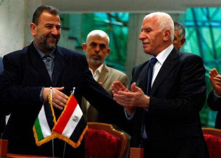 El jefe de la delegación de Hamas, Saleh Arouri, y el líder de Fatah, Azzam Ahmad, firman un acuerdo de reconciliación en El Cairo, Egipto, 12 de octubre de 2017 .. (crédito de foto: REUTERS / AMR ABDALLAH DALSH)