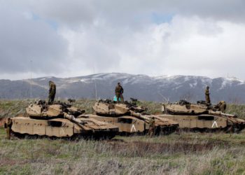 Los soldados israelíes están parados sobre tanques con vistas a la frontera entre Israel y Siria. (Crédito de la foto: RONEN ZVULUN / REUTERS)