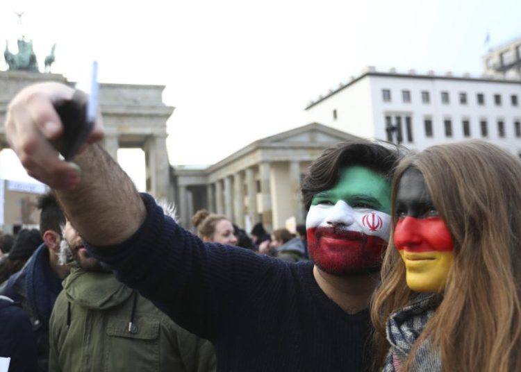 Una pareja, con la cara pintada con los colores de las banderas nacionales iraníes y alemanas, se toma una autofoto durante un mitin contra las políticas de inmigración del presidente de los Estados Unidos, Donald Trump, fuera de la embajada de los EE. UU. En Berlín, Alemania, 4 de febrero de 2017. (Crédito de la foto: REUTERS / PAWEL KOPCZYNSKI)