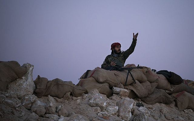 En esta foto de archivo del martes 19 de febrero de 2019, un combatiente de las Fuerzas Democráticas Sirias respaldado por Estados Unidos reacciona cuando un ataque aéreo golpea el territorio que aún mantienen los militantes del Estado Islámico en el desierto, fuera de Baghouz, Siria. (Foto AP / Felipe Dana)