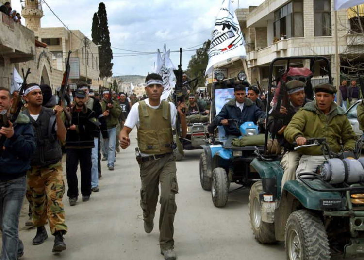 Zakaria Zubeidi, el comandante local del ala militar de Fatah, las Brigadas de los Mártires de Al-Aqsa y otros hombres armados marchan por las calles de la ciudad de Jenin en Cisjordania el 2 de abril de 2005. (Mohammed Ballas / AP Photo)